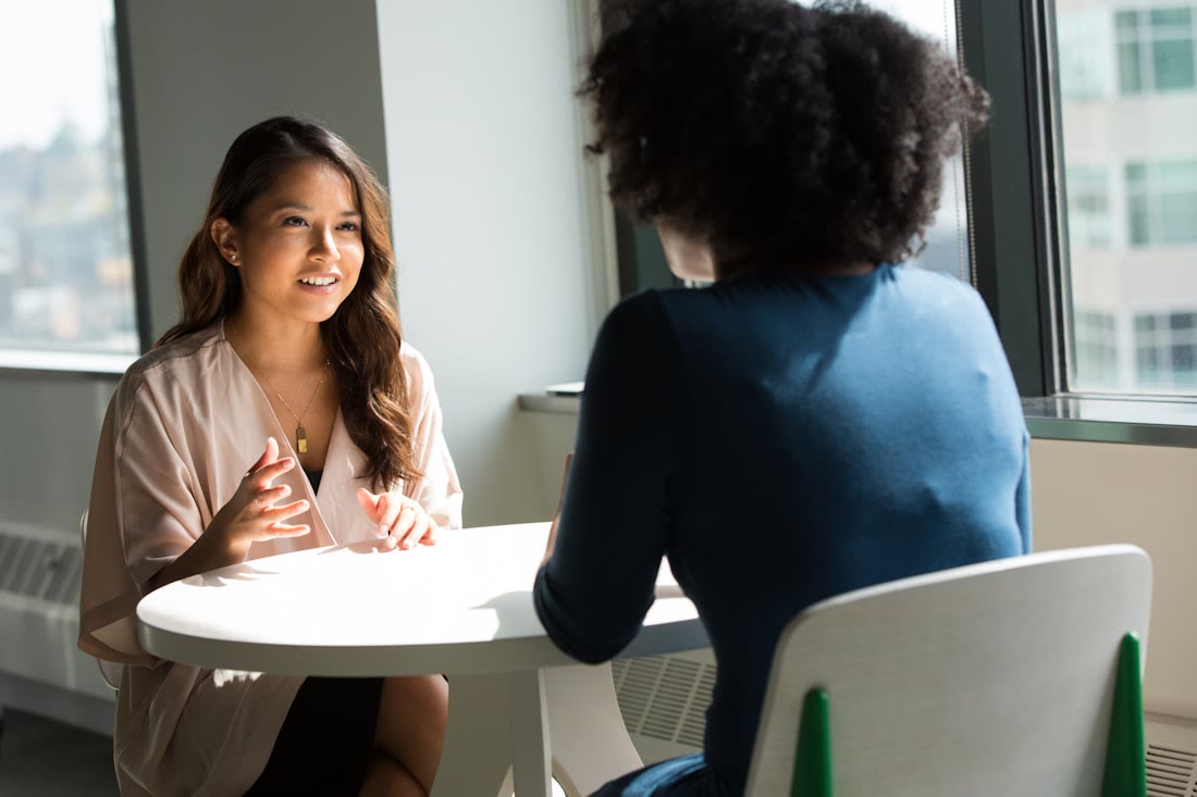 Two professionals in conversation at a table